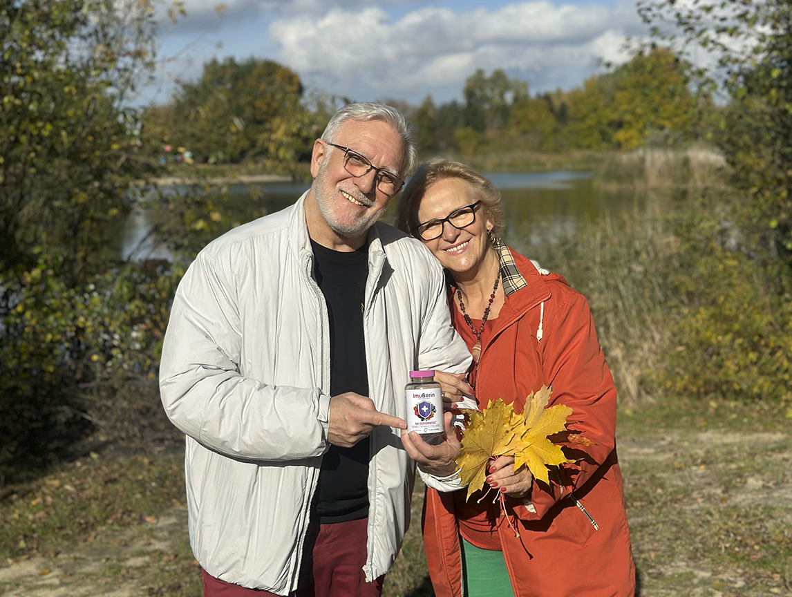 Natural Pharmaceuticals ImuBerin Laiminga vyresnio amžiaus pora lauke rodo ImuBerin maisto papildą imunitetui ir lauko gėrybes rudens fone.