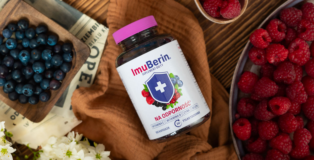 Natural Pharmaceuticals ImuBerin ImuBerin maisto papildo butelis guli ant rudos audinio, apsuptas aviečių, mėlynių ir baltų gėlių. Etiketėje pabrėžiamas imunitetą stiprinantis poveikis ir vitamino C, D, cinko bei seleno kiekis. Viskas pateikta natūralioje, apetitą keliančioje kompozicijoje.